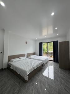 a bedroom with two beds and a large window at Dũng Đậu Homestay in Hai Phong