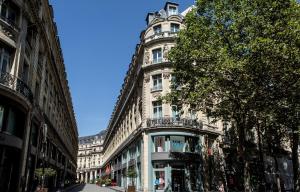 a tall white building on a city street at Hotel Indigo Paris - Opera by IHG in Paris