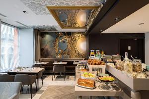 a restaurant with a table with food on it at Hotel Indigo Paris - Opera by IHG in Paris +166 photos
