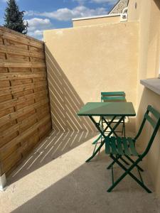 a green table and a green chair on a patio at Comme à la maison in Villiers-en-Bière