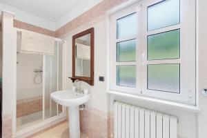 a white bathroom with a sink and a window at Cà da Trûcca in Varazze +29 photos