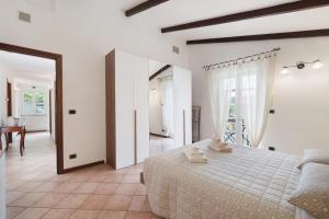 a white bedroom with a bed and a table at Cà da Trûcca in Varazze