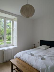 a bedroom with a bed and a table and windows at Chambres au vert - Proche aéroport et Nantes in Saint-Aignan-Grand-Lieu