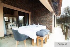 a white table with chairs and a brick wall at Majolie, Private Pool, Look Out Tower in Marloth Park +16 photos