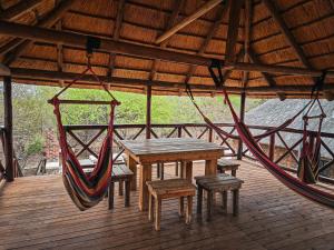 a porch with a hammock and a table and chairs at Majolie, Private Pool, Look Out Tower in Marloth Park