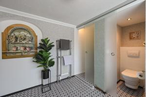 a bathroom with a toilet and a plant at Vintage Hotel Charivari- Sommer Hörnerbahnen kostenlos mit Restaurant in Bolsterlang +116 photos