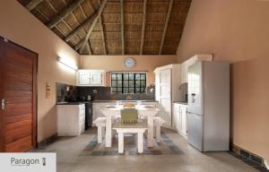 a kitchen with a table and a refrigerator at Majolie, Private Pool, Look Out Tower in Marloth Park