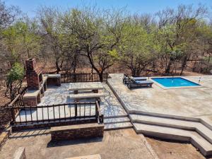 a backyard with a swimming pool and a firefficiencyfficiencyfficiencyfficiencyfficiencyfficiencybidden at Majolie, Private Pool, Look Out Tower in Marloth Park