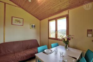 a living room with a couch and a table at Les Noës - Parc des chalets in Saint-Rirand