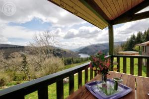 a table with a vase of flowers on a balcony at Les Noës - Parc des chalets in Saint-Rirand