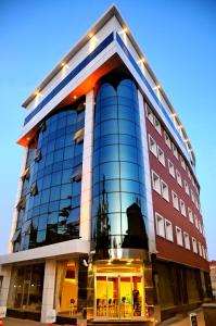 um edifício de vidro alto com luzes sobre ele em Ozpark Hotel em Aksehir