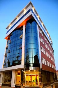 un edificio de cristal alto con luces. en Ozpark Hotel, en Aksehir