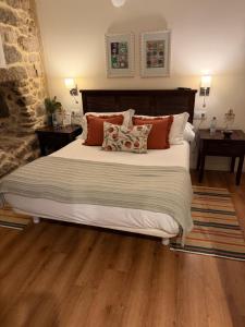 a bedroom with a large bed with pillows at Casa Herreria in Caldas de Reis
