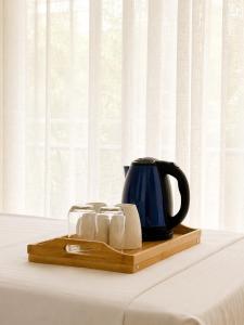 a tray with a tea kettle and slippers on a table at Kein Hotel in Durrës