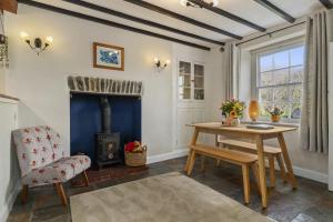 a living room with a table and a fireplace at Manteg - quaint holiday cottage by the sea with direct beach access in Aber-Arth