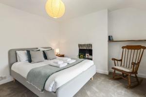 a bedroom with a large bed and a chair at Manteg - quaint holiday cottage by the sea with direct beach access in Aber-Arth