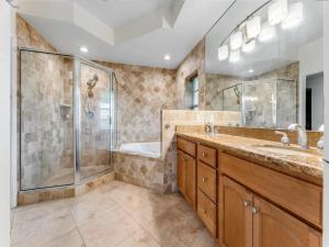 a bathroom with a shower and a sink and a tub at Elegant Waterfront Corner Residence in Key West