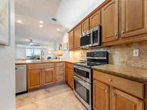 a kitchen with wooden cabinets and a stove top oven at Elegant Waterfront Corner Residence in Key West