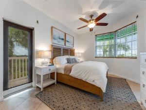 a bedroom with a bed and a ceiling fan at Elegant Waterfront Corner Residence in Key West