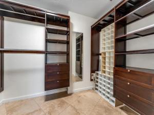 a walk in closet with wooden cabinets and a mirror at Elegant Waterfront Corner Residence in Key West