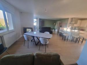 a living room and kitchen with a table and chairs at Maison confortable à Verdun avec jardin in Verdun-sur-Meuse +43 photos