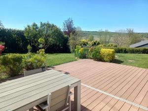 a wooden deck with a bench in a garden at Maison confortable à Verdun avec jardin in Verdun-sur-Meuse