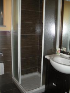 a shower with a glass door next to a sink at Podere Caselina b&b in Camugnano +17 photos