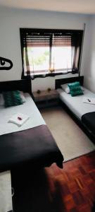 two beds in a room with a window at TurisMar Vila do Conde in Macieiro da Maia