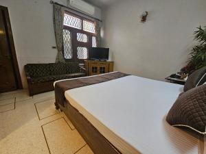 a bedroom with a bed and a chair and a window at The Green Villa in Ludhiana