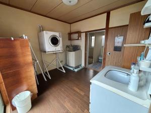 a kitchen with a washing machine and a microwave at 和の宿 禅 in Nachikatsuura