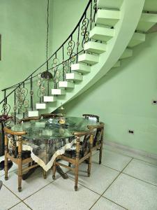 a dining room with a table and a staircase at The Green Villa in Ludhiana