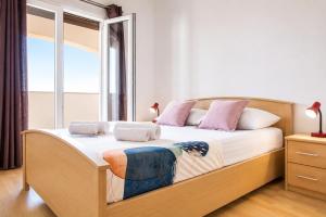 a bedroom with a large bed with a window at Dana Apartments - Seafront Pašman in Pašman