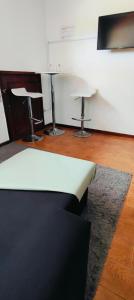 a living room with two bar stools and a table at TurisMar Vila do Conde in Macieiro da Maia