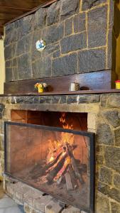 a brick fireplace with a fire in it at Bike Ville Fojo in Campos do Jordão