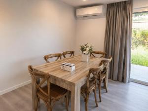 a dining room with a wooden table and chairs at 19 Pimpama Home in Pimpama