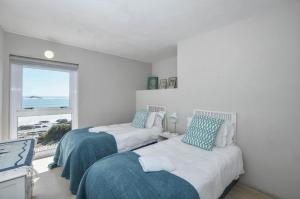 a bedroom with two beds and a window at Voetjieshang in Yzerfontein