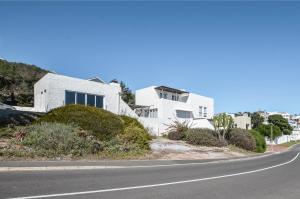 a white house on the side of a road at Voetjieshang in Yzerfontein