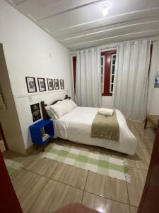 a bedroom with a large white bed in a room at Quartos em Tiradentes MG - A Casa Sarará in Tiradentes