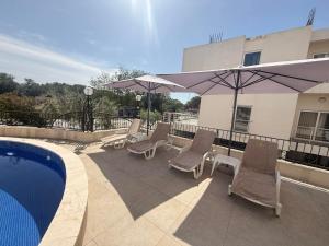 a group of chairs and umbrellas next to a pool at Hotel Dabi Imperial in Donji Štoj