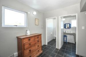 a room with a dresser and a bathroom with a window at Voetjieshang in Yzerfontein