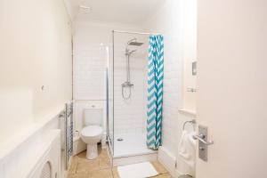 a bathroom with a toilet and a glass shower at Pier Court Apartments Brighton in Brighton & Hove +124 photos