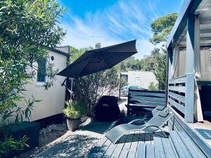 a patio with an umbrella and chairs on a deck at Danyja Mobilehome in Biograd na Moru +33 photos