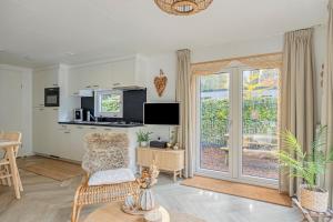 a living room with a sliding glass door at Knusse Tiny house op de Veluwe in Epe