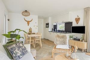 a living room with a couch and a table at Knusse Tiny house op de Veluwe in Epe