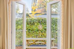 an open window with a view of a bench outside at Knusse Tiny house op de Veluwe in Epe
