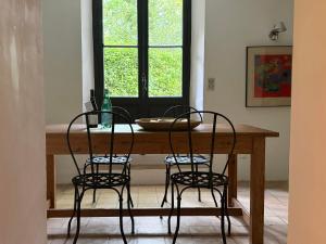a dining room table with two chairs and a window at La Suite de la Bastide in Val-de-Dagne