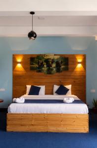 a bedroom with a large bed with a wooden headboard at Off grid Ella Homestay in Ella