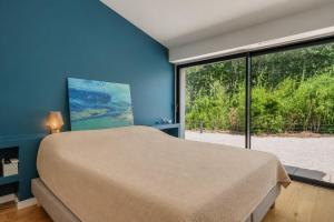 a bedroom with a bed and a large window at Villa avec piscine chauffée, proche Saint-Tropez et plages in Gassin +11 photos