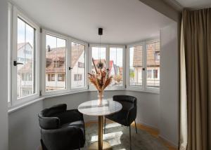 a room with a table and chairs and windows at Moe by Limehome in Freudenstadt