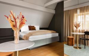 a bedroom with a bed and a table with flowers on it at Moe by Limehome in Freudenstadt